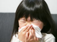 花粉症で鼻水がとまらない少女
